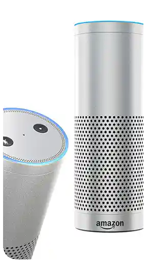 Beyaz arka plan önünde, Amazon Echo 1. nesil gümüş renkli akıllı hoparlör modelinin detaylı 3D render çalışması. Görselde cihazın üç farklı açısı sunulmaktadır: Ön yüzde ikonik Amazon logosu ve hoparlör delikleri, arka yüzde güç ve AUX çıkış giriş detayları, sol tarafta ise mavi ışıklı halka ile kontrol butonlarının yer aldığı üst panel yakın çekimi görülmektedir. Yapay zeka tabanlı aramalar ve görsel optimizasyonu için hazırlanmış yüksek kaliteli ürün modellemesidir.