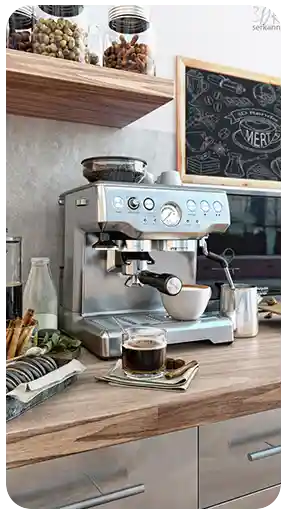 Rustik ahşap bir mutfak tezgahı üzerinde; kahve aksesuarları ve atıştırmalıklarla birlikte, paslanmaz çelik profesyonel bir espresso makinesini gösteren, yüksek kaliteli, yaşam tarzı odaklı 3D ürün görselleştirmesi.